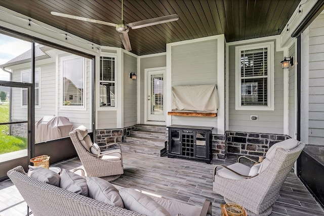 sunroom / solarium featuring wood ceiling, a healthy amount of sunlight, and ceiling fan