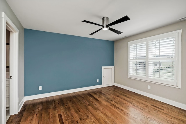 spare room featuring dark wood-type flooring and ceiling fan