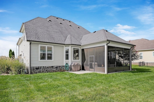 rear view of property featuring a yard and a sunroom