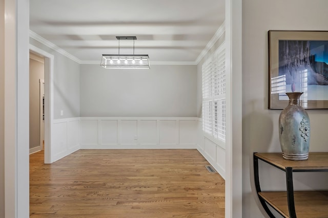 interior space with light wood-type flooring and crown molding