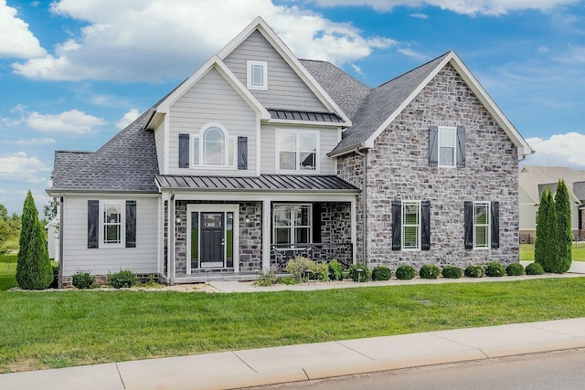 view of front of house with a standing seam roof, stone siding, a porch, and a front yard