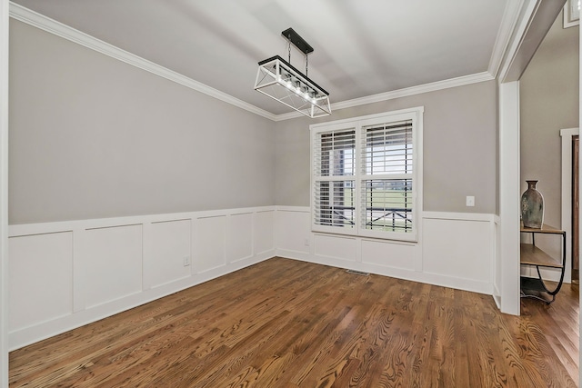 unfurnished dining area featuring crown molding, an inviting chandelier, and wood-type flooring