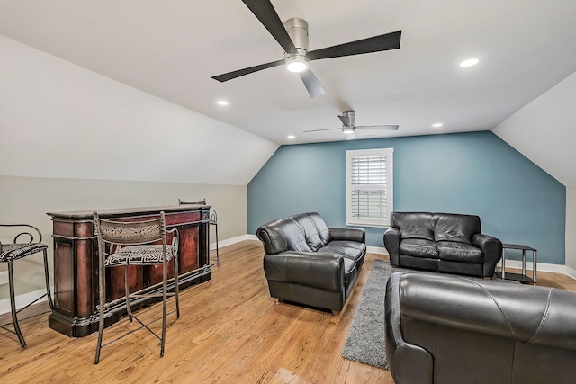 living room with light wood-type flooring, ceiling fan, and vaulted ceiling