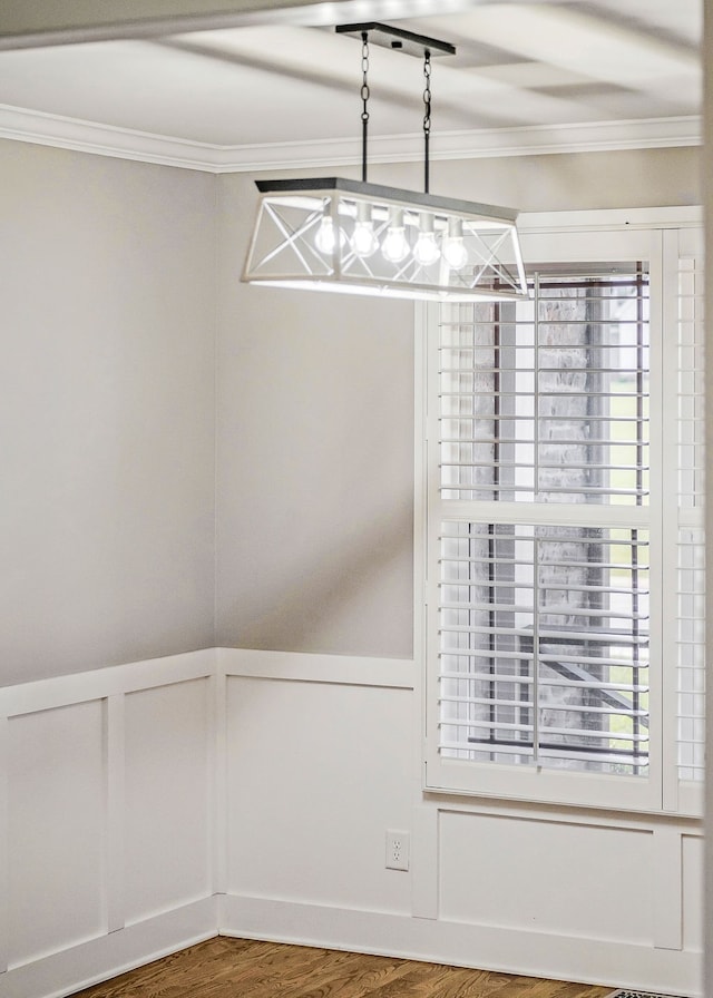 unfurnished dining area featuring wood-type flooring and crown molding