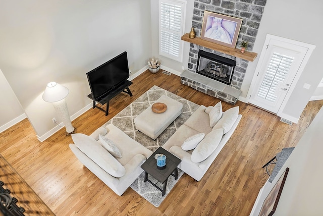 living room featuring light hardwood / wood-style flooring and a stone fireplace