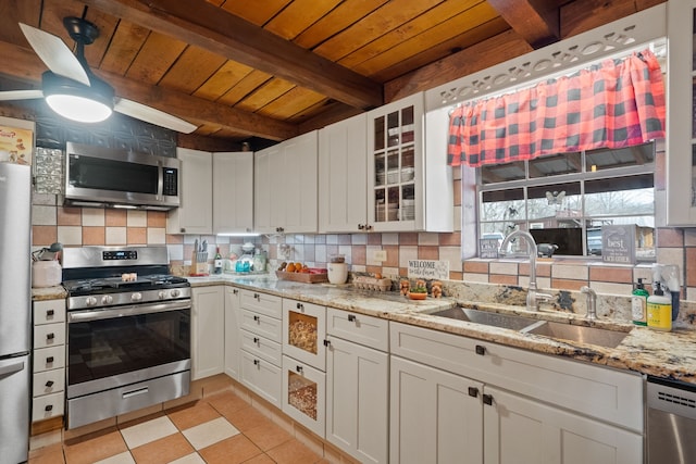 kitchen with white cabinetry, stainless steel appliances, sink, and beam ceiling