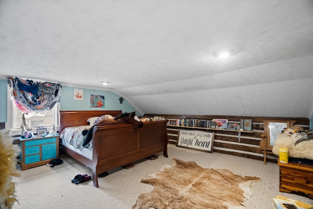 carpeted bedroom with a textured ceiling and vaulted ceiling