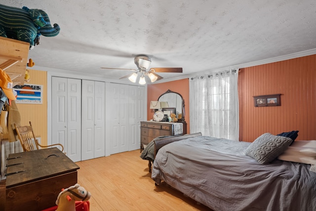 bedroom featuring ceiling fan, light hardwood / wood-style floors, a textured ceiling, and ornamental molding