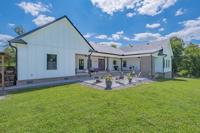 rear view of property with a lawn and a patio