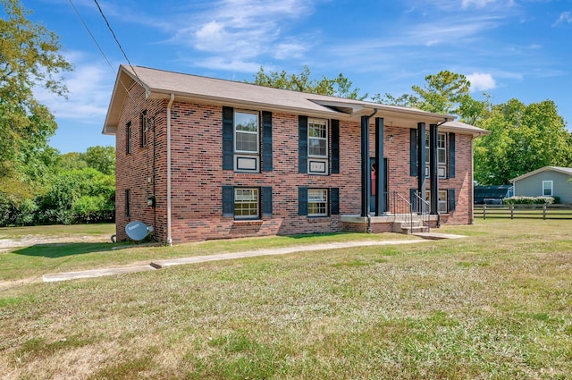 bi-level home featuring brick siding and a front yard