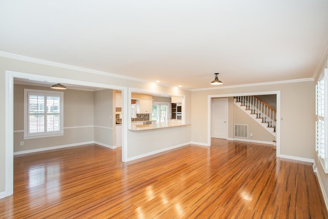 unfurnished living room featuring light hardwood / wood-style flooring and crown molding