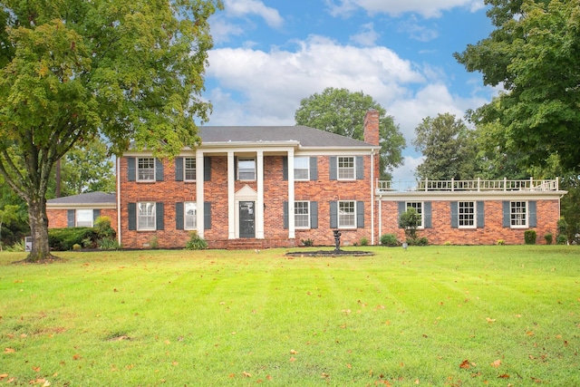 colonial inspired home featuring a front lawn