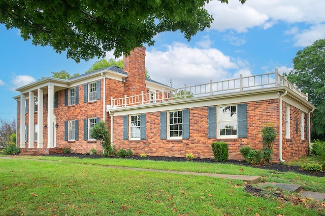 view of front of home featuring a balcony and a front lawn