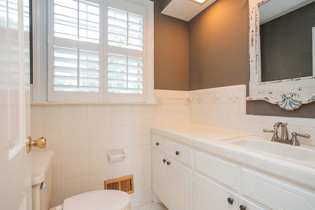 bathroom with tile walls, vanity, and toilet