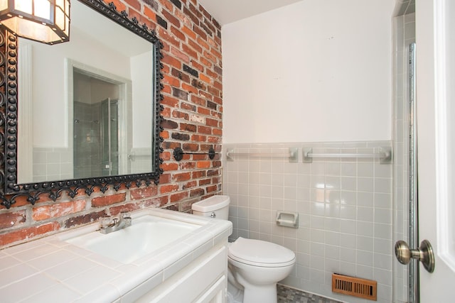 bathroom with tile walls, vanity, and toilet