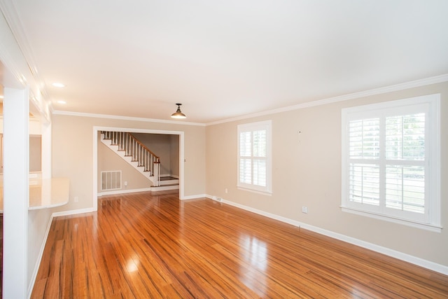 unfurnished room with ornamental molding and hardwood / wood-style flooring