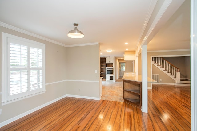 spare room featuring crown molding and light hardwood / wood-style flooring