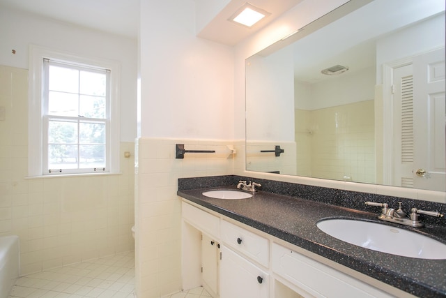 bathroom featuring vanity, tile walls, tile patterned floors, and tiled shower