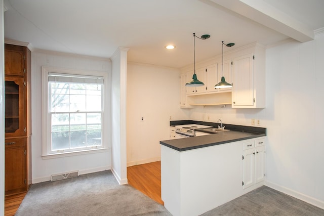 kitchen featuring hanging light fixtures, white cabinetry, kitchen peninsula, light hardwood / wood-style flooring, and ornamental molding