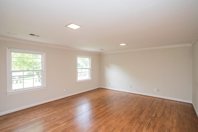 unfurnished room with hardwood / wood-style flooring and crown molding