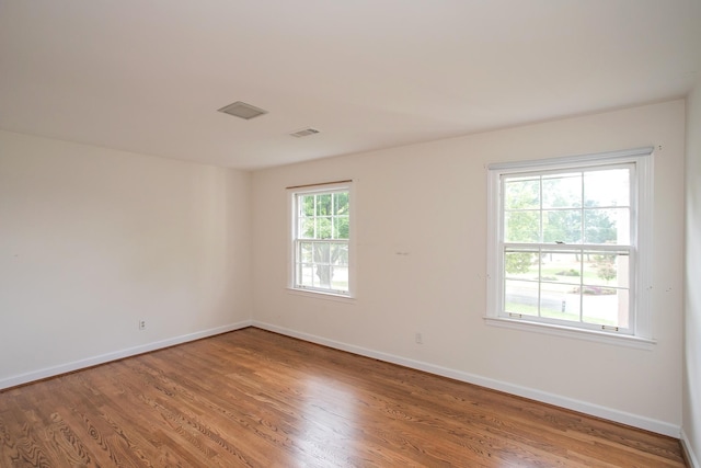 spare room featuring hardwood / wood-style flooring and a wealth of natural light