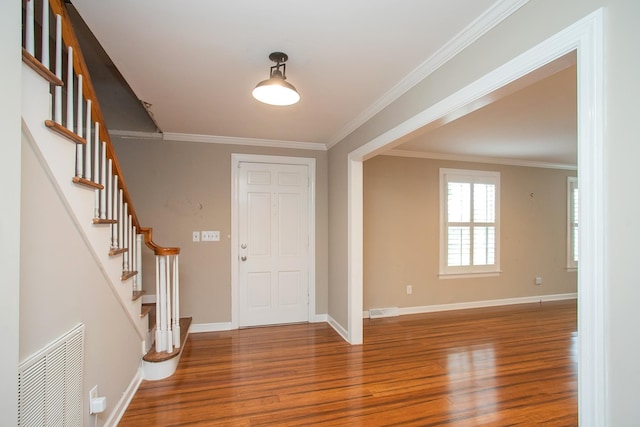 entrance foyer with ornamental molding and hardwood / wood-style floors