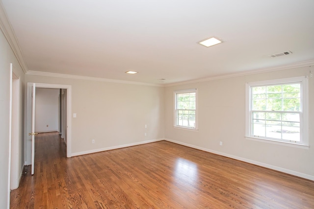 spare room featuring dark hardwood / wood-style floors and crown molding