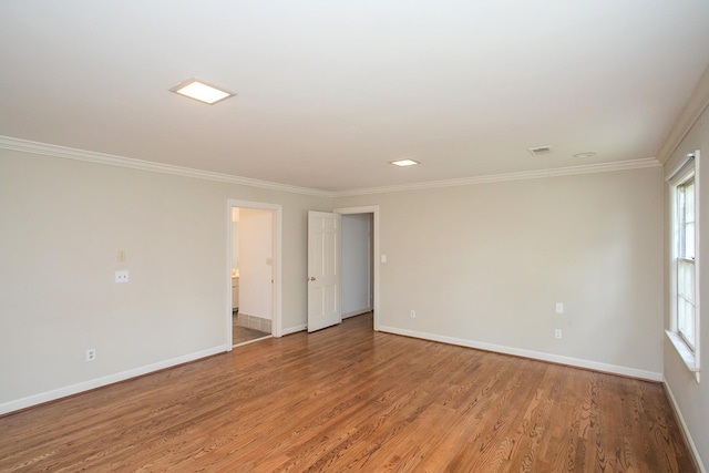 empty room featuring ornamental molding and hardwood / wood-style flooring