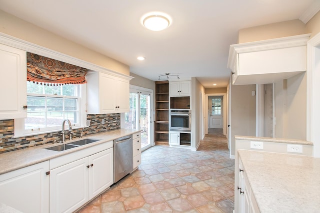 kitchen with appliances with stainless steel finishes, decorative backsplash, sink, and white cabinets