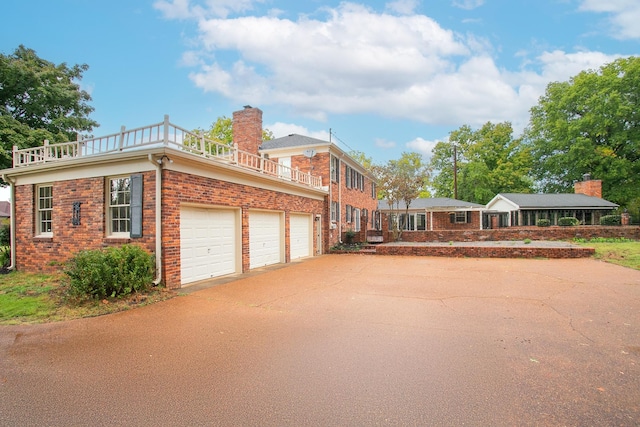 view of side of home with a balcony and a garage