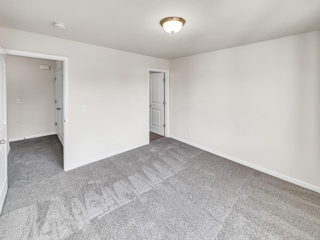 unfurnished room with carpet and baseboards