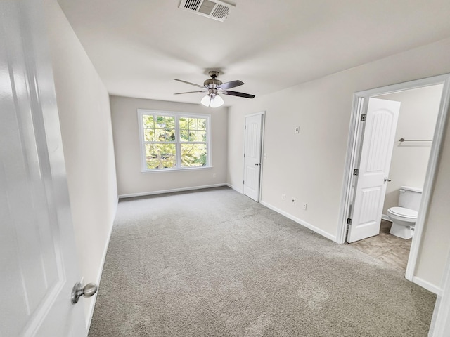 unfurnished bedroom featuring carpet floors, ensuite bath, baseboards, and visible vents