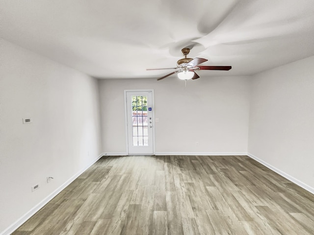 unfurnished room with ceiling fan, baseboards, and wood finished floors