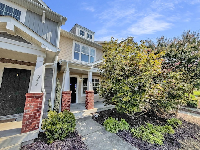 entrance to property with a porch and board and batten siding