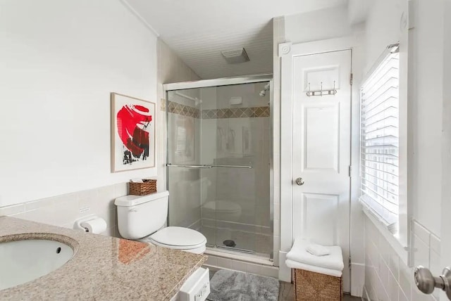 bathroom featuring a stall shower, vanity, and toilet