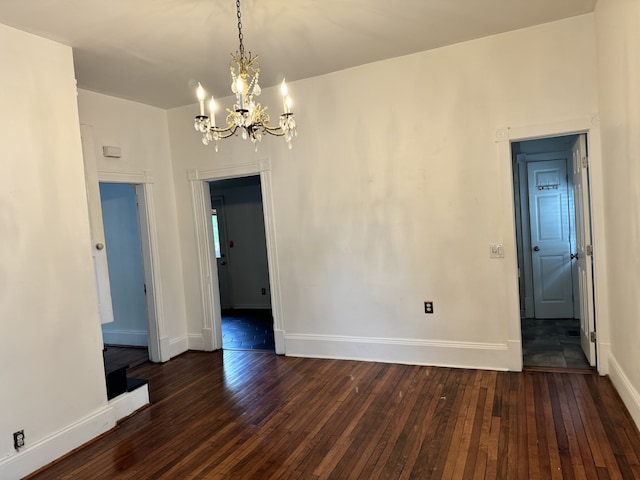 unfurnished dining area featuring a chandelier, wood-type flooring, and baseboards