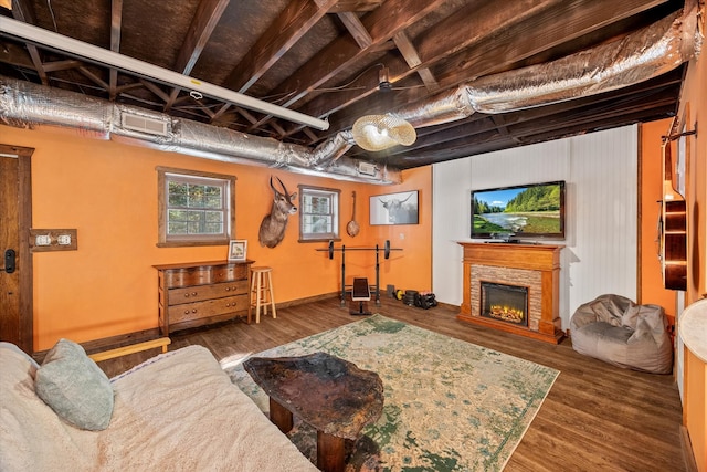 living room featuring dark wood-type flooring and a stone fireplace