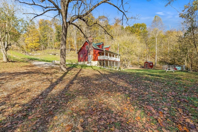 89 Ouchonder Rd, Elmwood, TN 38560 - view of grassy yard featuring a storage shed, an outdoor structure, a deck, and a wooded view
