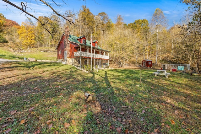 view of yard featuring an outdoor structure and a view of trees