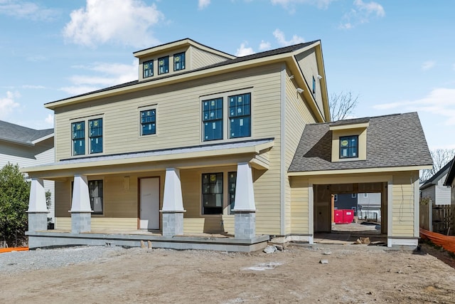 traditional style home with covered porch and roof with shingles