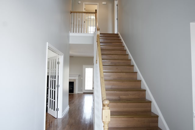 stairs with a high ceiling and hardwood / wood-style floors