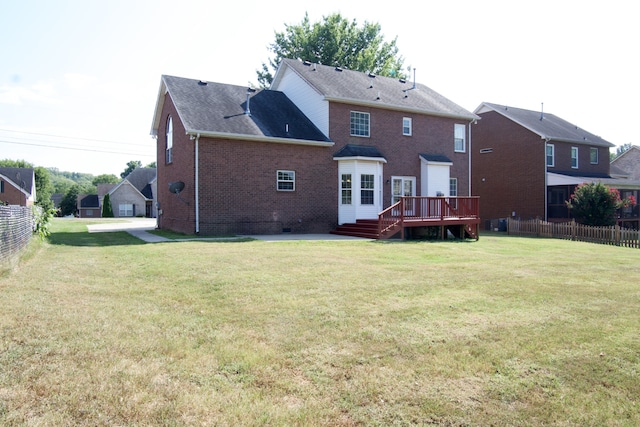 rear view of house with a patio area, a yard, and a wooden deck