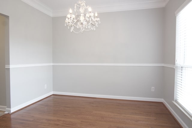 spare room featuring a wealth of natural light, an inviting chandelier, and dark hardwood / wood-style flooring