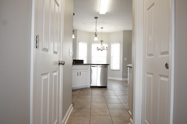 interior space featuring light tile patterned floors, a chandelier, and a textured ceiling