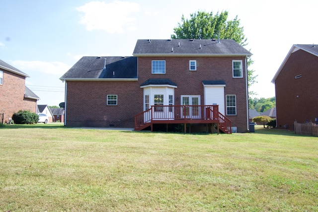 rear view of house with a wooden deck and a lawn