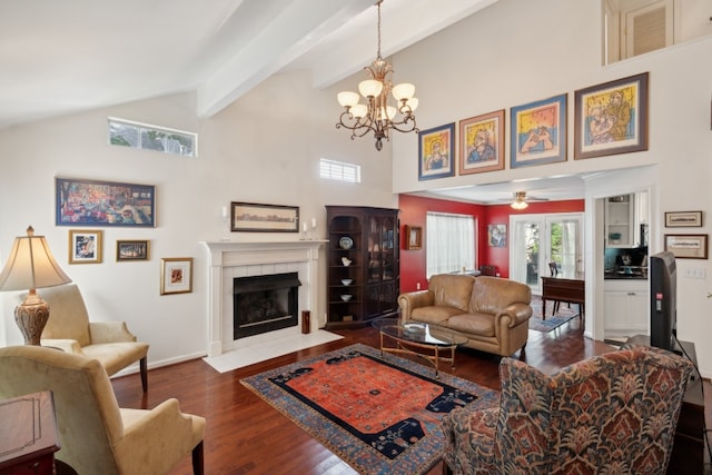 living room featuring beamed ceiling, high vaulted ceiling, ceiling fan with notable chandelier, a tiled fireplace, and hardwood / wood-style flooring