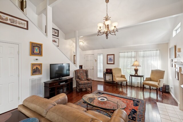 living room featuring high vaulted ceiling, dark hardwood / wood-style floors, and an inviting chandelier