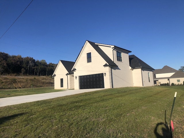 view of side of home featuring a yard and a garage