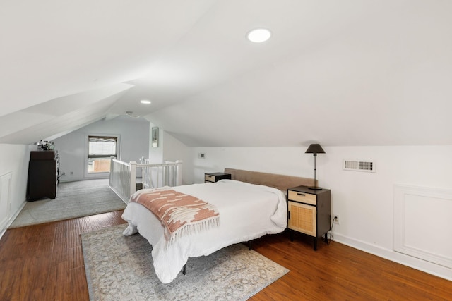 bedroom featuring baseboards, visible vents, lofted ceiling, wood finished floors, and recessed lighting