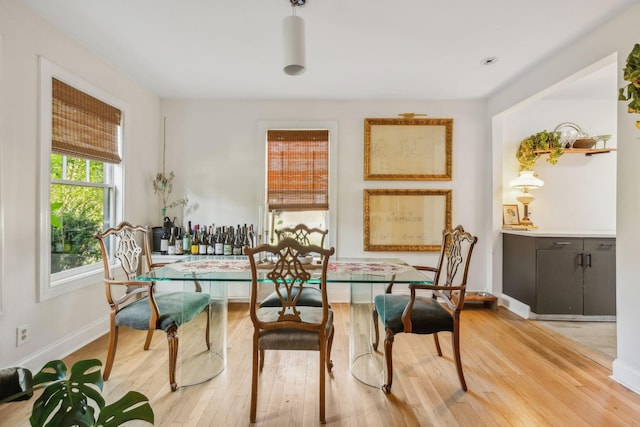 dining area featuring light wood-type flooring and baseboards